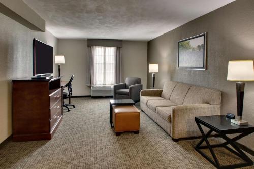 a living room with a couch and a tv at Drury Inn & Suites San Antonio Northwest Medical Center in San Antonio