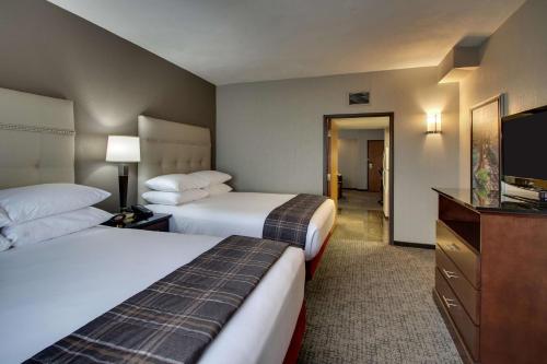 a hotel room with two beds and a flat screen tv at Drury Inn & Suites San Antonio Northwest Medical Center in San Antonio