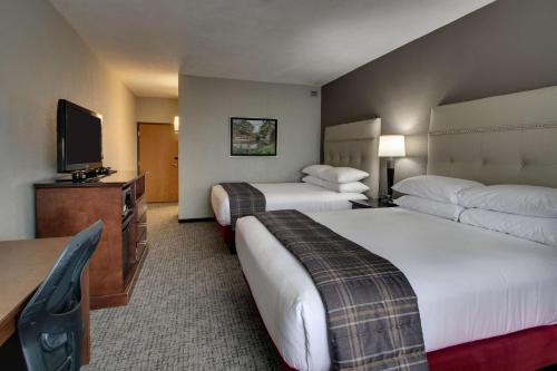 a hotel room with two beds and a flat screen tv at Drury Inn & Suites San Antonio Northwest Medical Center in San Antonio