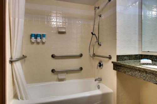 a bathroom with a shower and a white tub at Drury Inn & Suites San Antonio Northwest Medical Center in San Antonio