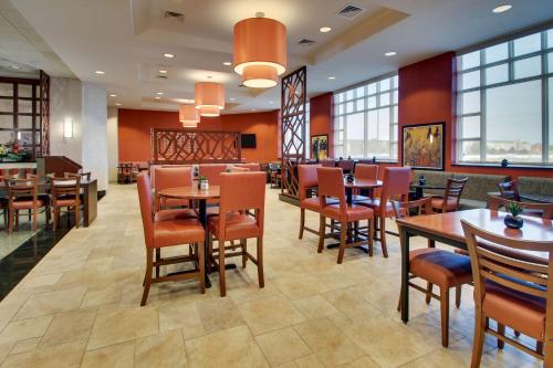 a restaurant with tables and chairs and windows at Drury Inn & Suites Findlay in Findlay