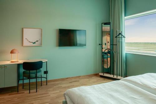 a bedroom with a bed and a desk and a window at Scandic Landvetter in Landvetter