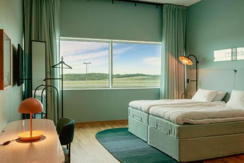ein Schlafzimmer mit einem Bett und einem großen Fenster in der Unterkunft Scandic Landvetter in Landvetter