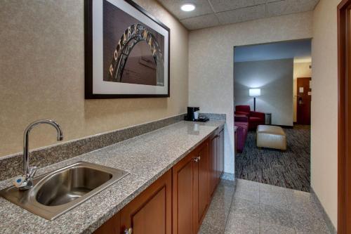 a kitchen with a sink and a living room at Drury Inn & Suites Findlay in Findlay