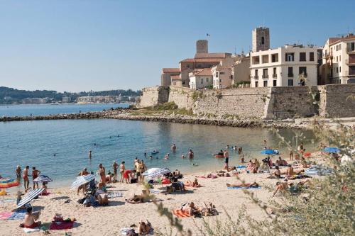 un gruppo di persone su una spiaggia vicino all'acqua di Séjour sur voilier a Antibes