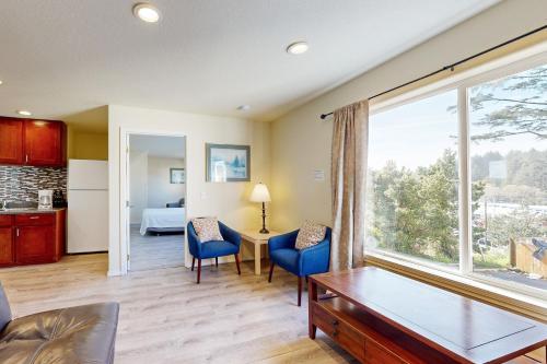 Una sala de estar con una mesa y sillas y una gran ventana. en Seal Three Condo Getaway, en Lincoln City