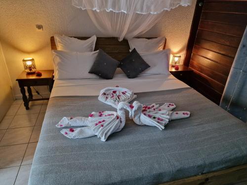 una camera da letto con un letto e asciugamani di La Colline Verte a Deshaies