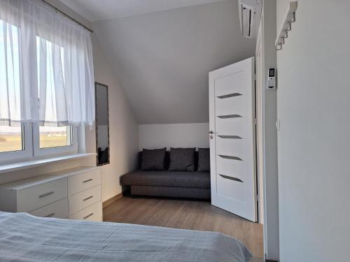 1 dormitorio con cama, ventana y sofá en Villetta Rewal, en Rewal