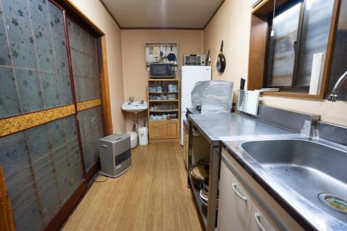 La cuisine est équipée d'un évier et d'un réfrigérateur. dans l'établissement Minsyuku Mirai - Vacation STAY 94810v, à Tōkamachi