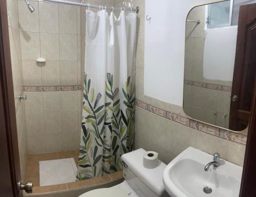 a bathroom with a sink and a shower curtain at HOTEL PAL-MAR in Atacames