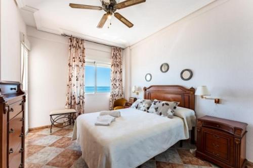 a bedroom with a bed and a ceiling fan at Fuengirola Primera Línea de Playa in Fuengirola