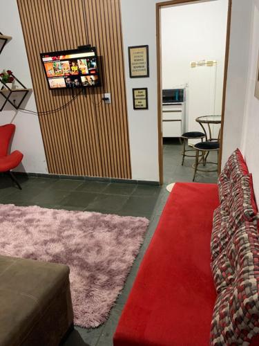 uma sala de estar com um sofá e um tapete vermelho em kitnet para casal em Taguatinga-DF em Brasília
