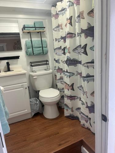 a bathroom with a toilet and a shower curtain with fish at The Bait & Tackle - Newly renovated suite apt 2 in Bryson City