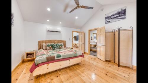 a bedroom with a bed and a wooden floor at #2 Cottage Like Suite With Private Hot Tub in Bass Lake