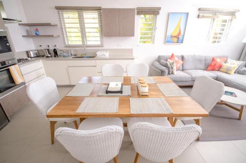 a kitchen and living room with a wooden table and chairs at L'Escale 3 bedrooms Sea View and Beachfront Suite by Dream Escapes in Tamarin