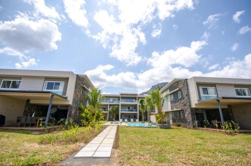 an exterior view of a building with a yard at L'Escale 3 bedrooms Sea View and Beachfront Suite by Dream Escapes in Tamarin