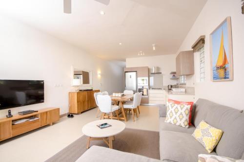 a living room with a couch and a table at L'Escale 3 bedrooms Sea View and Beachfront Suite by Dream Escapes in Tamarin