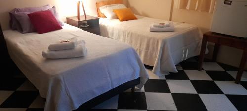 2 camas con toallas en una habitación de hotel en lugar tranquilo en Vicente López