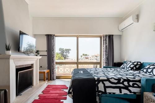 a bedroom with a bed and a fireplace and a television at OURA WHITE VIEW Beach 2 min walk sea in Albufeira
