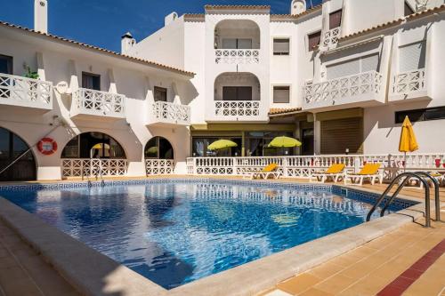 a swimming pool in front of a building at OURA WHITE VIEW Beach 2 min walk sea in Albufeira