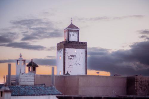 un edificio con una torre dell'orologio sopra di Giraffe Hostel -Sea View Rooftop a Essaouira