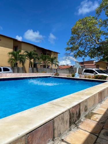 a large blue swimming pool next to a building at Apartamento em Ilha De Itamaracá in Vila Velha