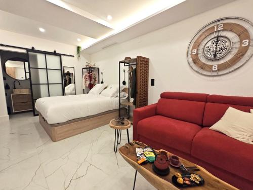 a living room with a red couch and a bed at La Parada del Rey - Luxury Suites in Plasencia