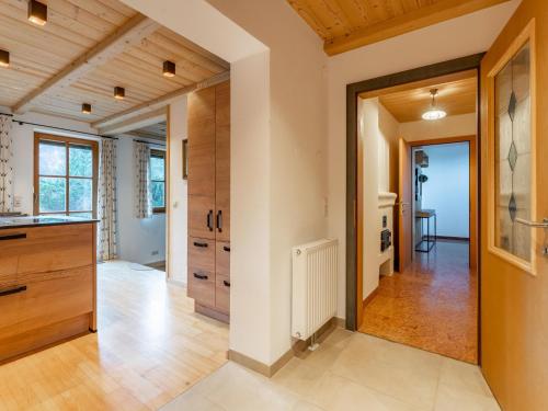 uma cozinha com tectos em madeira e um corredor com uma porta em Spykerhütte em Rauris
