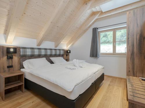 duże łóżko w pokoju z drewnianym sufitem w obiekcie Vita Montagna w mieście Donnersbachwald