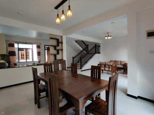 a dining room and living room with a wooden table and chairs at Limitless in Sri Jayewardenepura Kotte