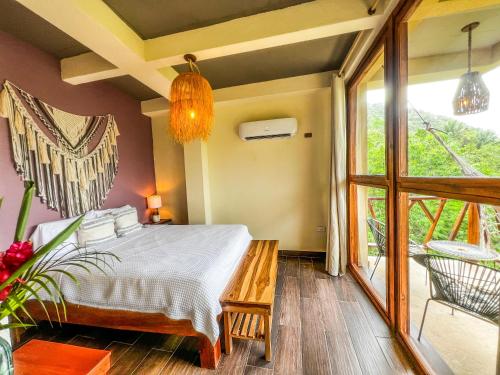 a bedroom with a bed and a large window at Villa Tayrona in El Zaino