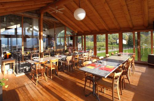 ein Restaurant mit Tischen und Stühlen auf einem Holzboden in der Unterkunft Osteria Ritrovo dei Passeggeri in SantʼAntonio