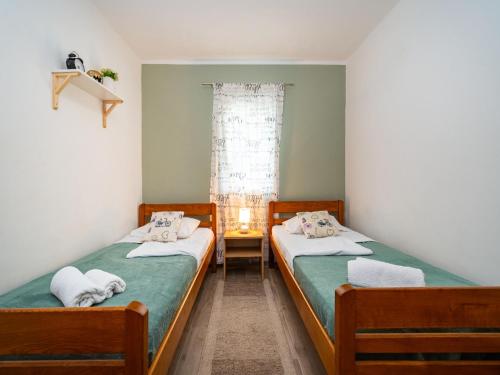 two twin beds in a room with a window at Apartments with a parking space Nin, Zadar - 10414 in Nin