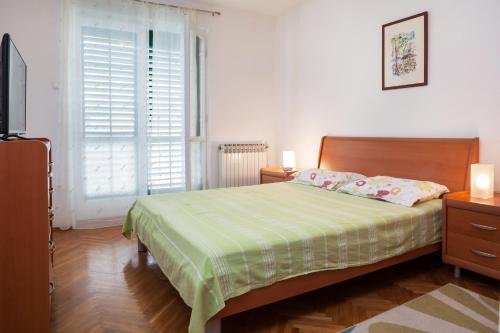 1 dormitorio con 1 cama, TV y ventana en Apartment Nevia, en Makarska