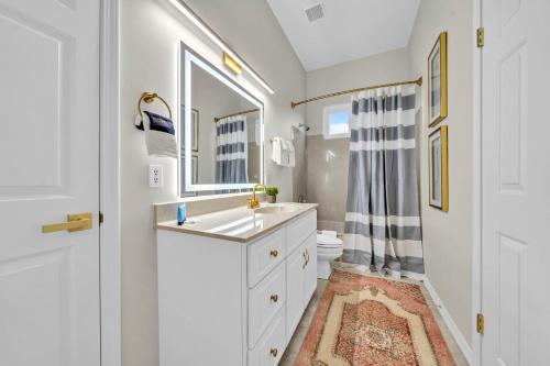 a bathroom with a sink and a toilet and a mirror at Blue Mountain Home with 2 Masters and a Private Pool while only 300 ft to Beach in Santa Rosa Beach