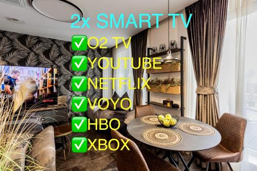 a dining room with a table and a sign that reads x smart tv versus you at DH Private Flowers Terrace and Sauna Luxury Apartment 2kk, 2x SmartTV-NETFLIX, Free Parking, Gym in Brno