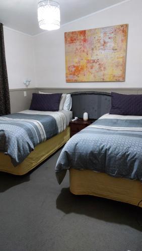 two beds sitting next to each other in a bedroom at Bed and Breakfast Happy Home Taupo Accommodation in Taupo