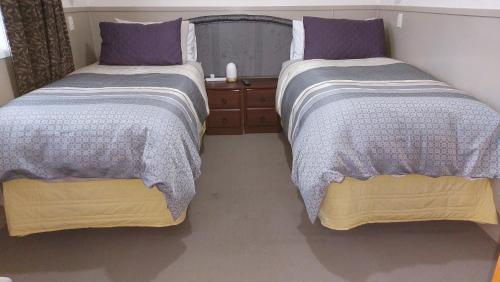 two beds sitting next to each other in a bedroom at Bed and Breakfast Happy Home Taupo Accommodation in Taupo
