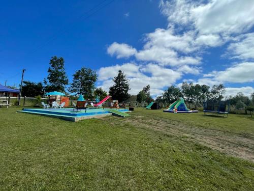 un parque con varias estructuras de juego en un campo en El pantano de sherk y fiona, en San José de la Mariquina