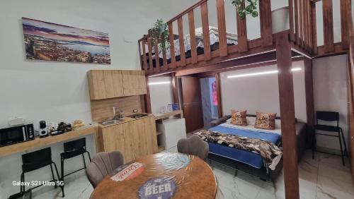 Zimmer mit einem Etagenbett, einem Tisch und einer Küche in der Unterkunft San Ciro's Suite in Portici