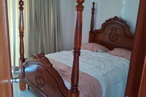 a bed with a wooden frame in a bedroom at Appartamento Sidney in San Fernando de Monte Cristi