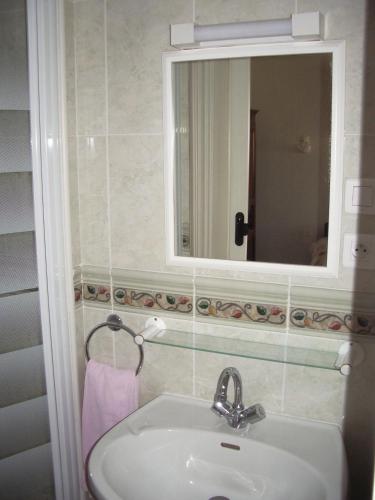 une salle de bain avec un lavabo et un miroir dans l'établissement Les Glycines, à Plaimpied-Givaudins