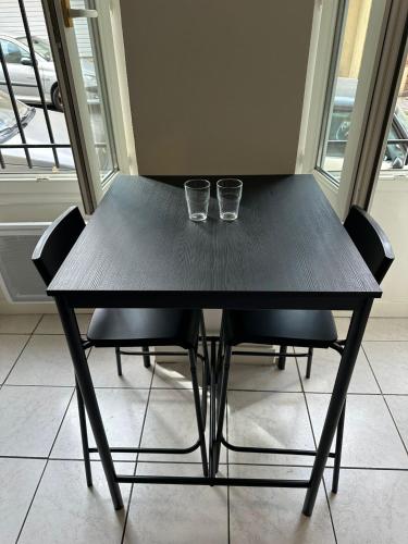 dois copos sentados numa mesa com cadeiras em Studio One Bed, One Sofa - TV little Kitchen em Marselha