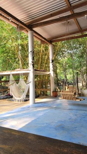 a porch with a hammock hanging from a roof at Pachamaya Hostel in Lanquín