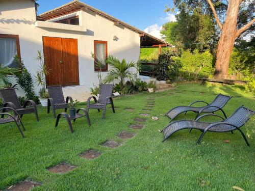 a group of chairs sitting in a yard at Casa paradise perto da praia Guarajuba - BA in Camacari