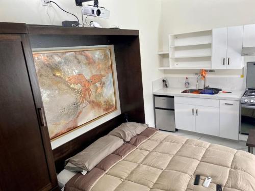 a bedroom with a bed and a painting on the wall at Loft, Departamento Con cocina, Súper Lujo, Cuarzo in Monterrey