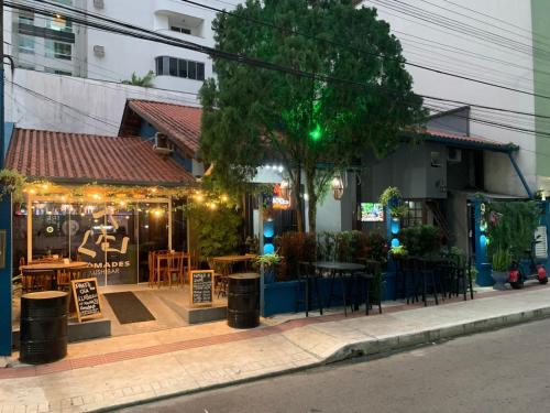 a restaurant with tables and chairs on a street at Nômades Club House in Balneário Camboriú