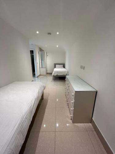 Cette chambre blanche dispose de 2 lits et d'un lit sidx sidx sidx sidx. dans l'établissement Lovely Home in Kimmage, Dublin, à Dublin