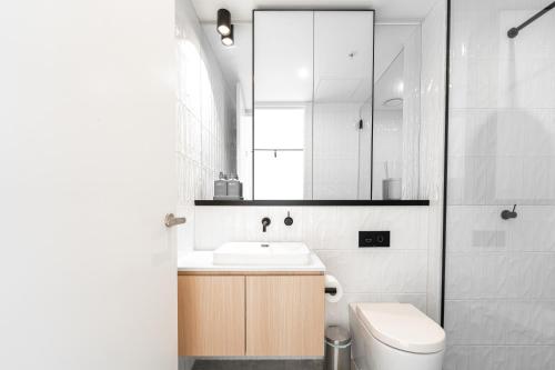 a bathroom with a sink and a toilet and a mirror at Asteroid B-612 Urban Bliss Retreat in Melbourne