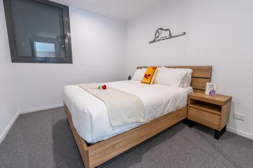 a bedroom with a large bed with a wooden frame at Asteroid B-612 Urban Bliss Retreat in Melbourne